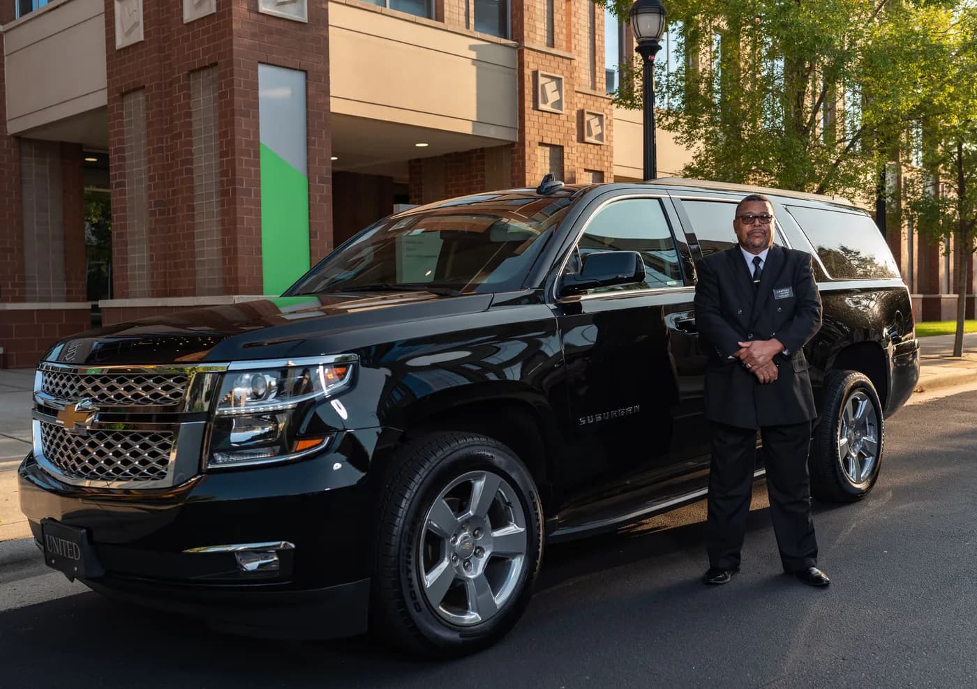 Black luxury SUV with chauffeur at a city pickup