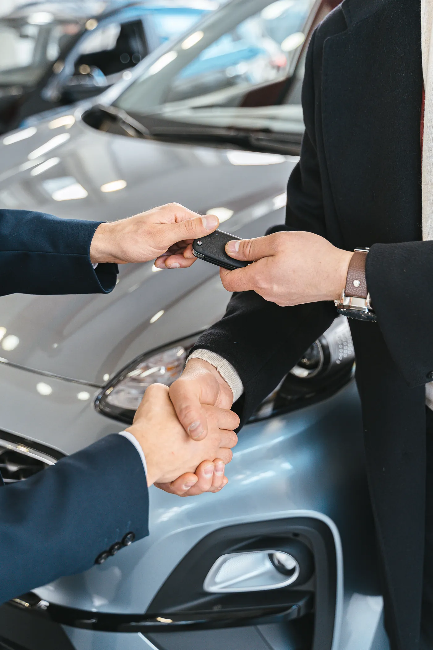 Business client greeting a chauffeur beside a black vehicle